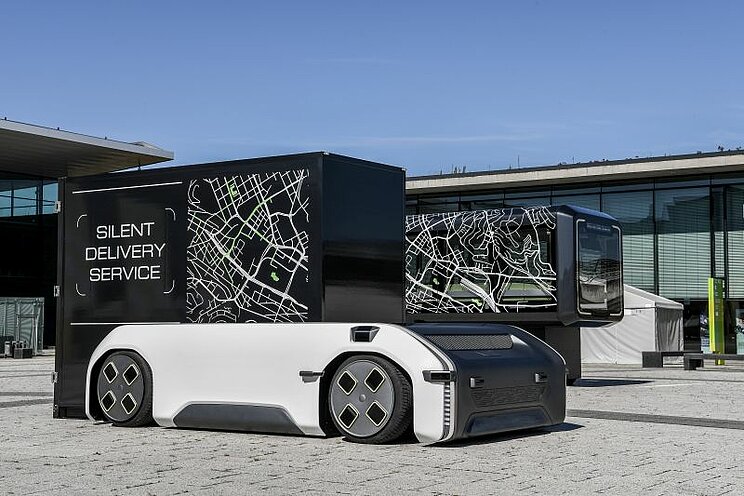Das Foto zeigt ein autonomes, fahrerloses, elektrisches Fahrzeugkonzept U-Shift vor einem Gebäude.