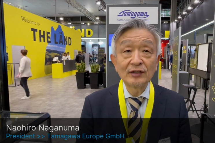 Naohiro Naganuma steht auf dem THE LÄND Stand auf der Hannover Messe, unter ihm wird in einer Bauchbinde der Name eingeblendet.