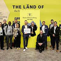 Gruppenfoto mit den Teilnehmenden am Messerundgang des Clusters Elektromobilität Süd-West auf der Hannover Messe.