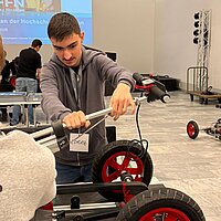 Zwei Jungen bauen ein Elektro-Kart zusammen.