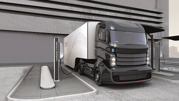 Ein grauer LKW mit alternativen Antrieb an einer Ladestation.