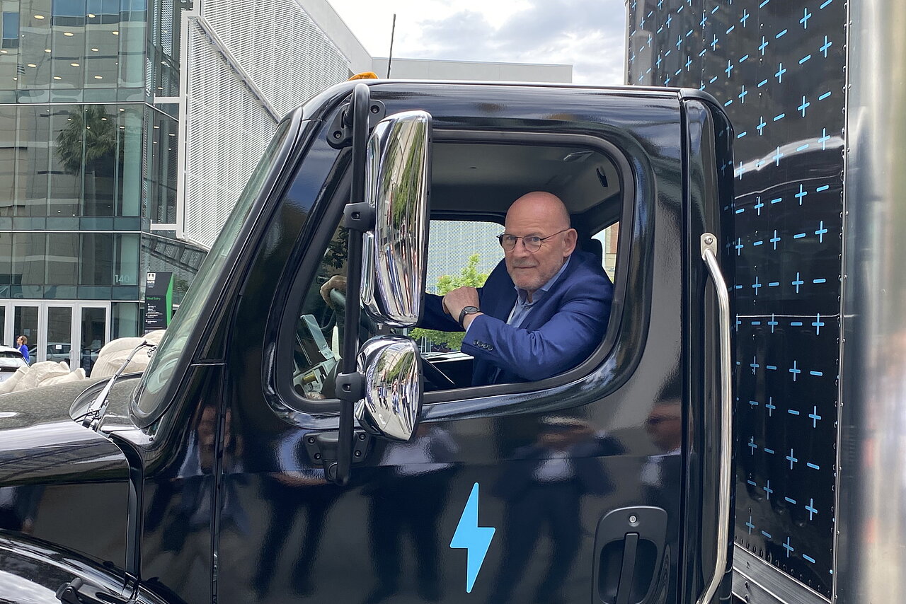 Verkehrsminister Winfried Hermann sitzt in einem elektrischen Lkw und schaut aus dem Fenster