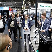 Rundgang über die Messe organisiert vom Cluster Elektromobilität Süd-West mit mehreren Teilnehmer: innen.