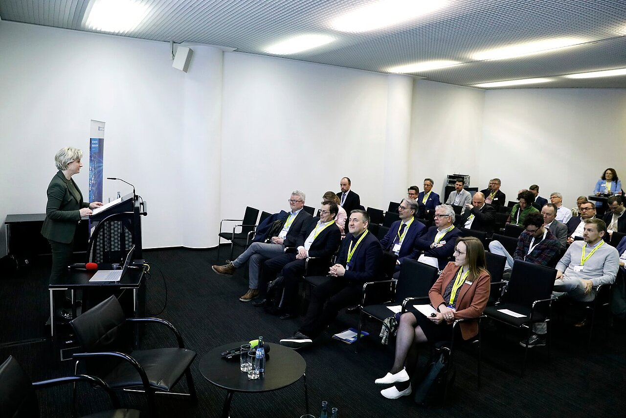 Die Wirtschaftsministerin Dr. Nicole Hoffmeister-Kraut eröffnet den Batterietag Cluster ESW. Im Publikum sitzen die Teilnehmenden.