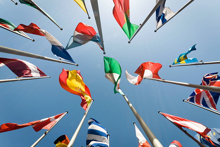 Aufnahme aus Froschperspektive auf zahlreiche internationale Flaggen