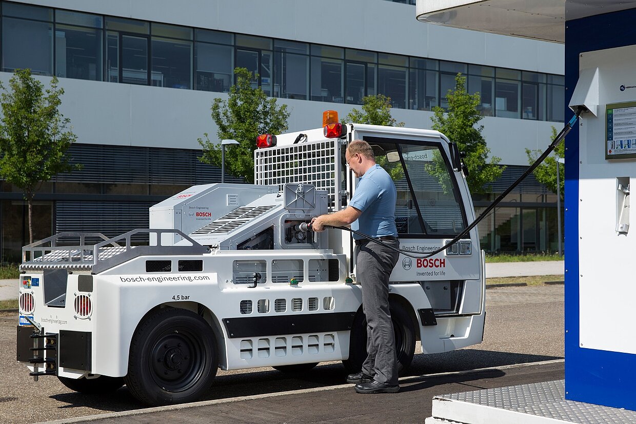 Ein elektrifizierter Gepäckschlepper an einer Ladestation.