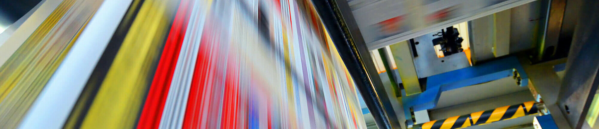 Druckpapier einer Zeitung läuft über eine Walze.