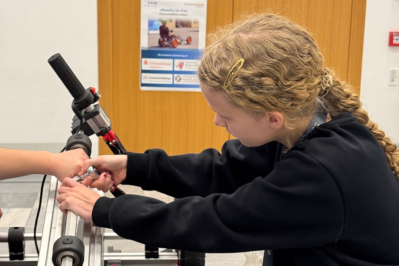 Ein Mädchen baut ein Elektro-Kart zusammen.
