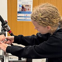 Ein Mädchen baut ein Elektro-Kart zusammen.