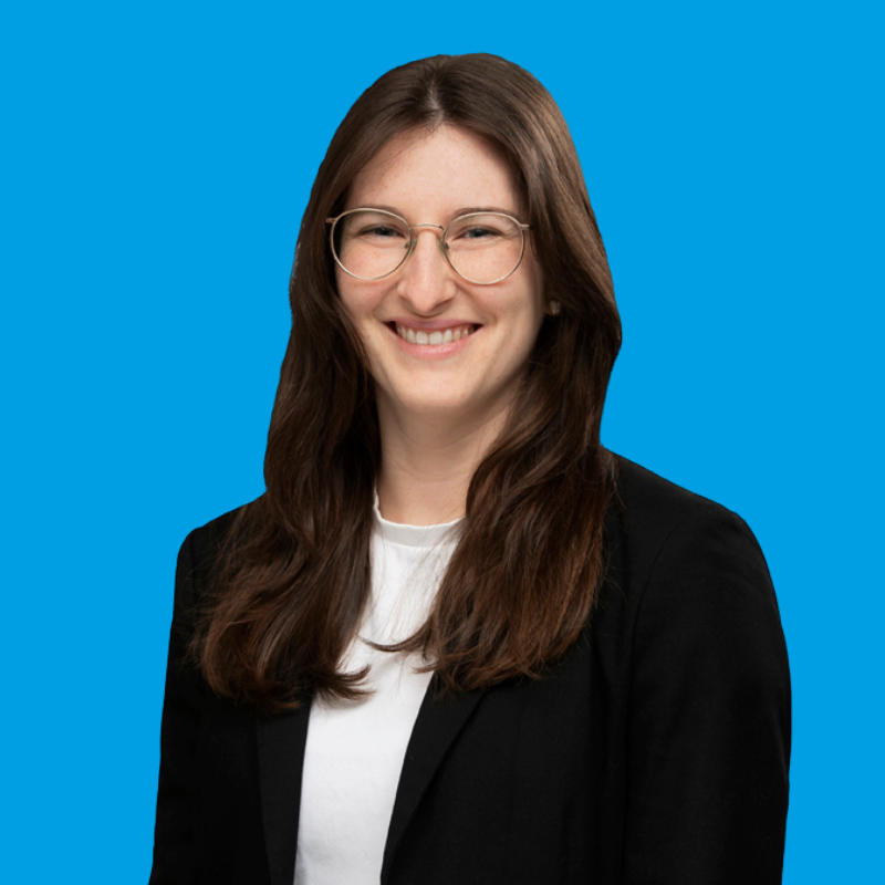 Porträtfoto von Katharina Bessing auf blauem Hintergrund
