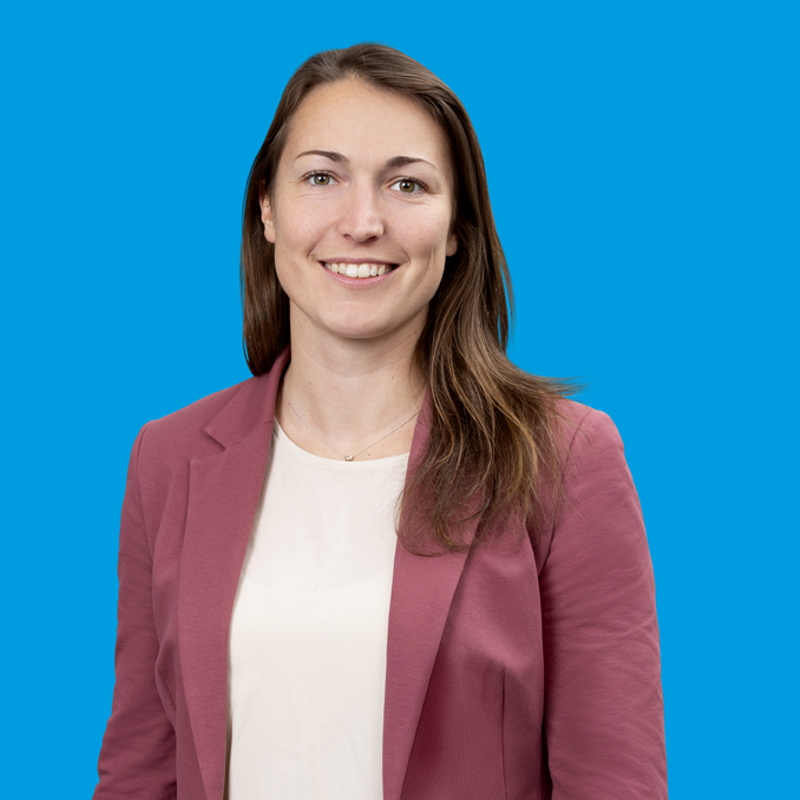 Portrait von Saskia Schüttke vor blauem Hintergrund